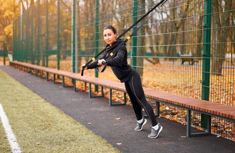 女孩运动员培训体育运动地面混合<strong>比赛</strong>年轻的成人女人锻炼悬架系统健康的生活方式伸展运动在户外<strong>操场</strong>上