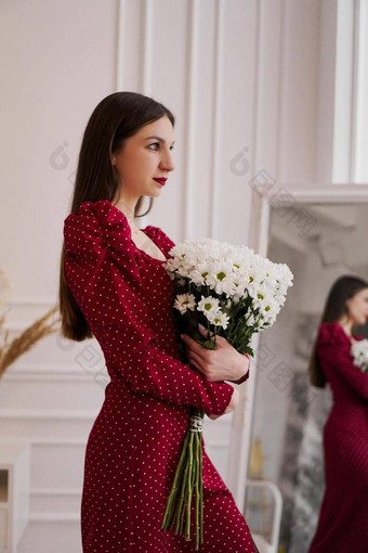 美丽的浅黑肤色的女人红色的衣服花束雏菊首页