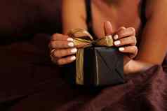 女人打开礼物黑色的盒子黄金丝带