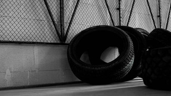 <strong>轮胎仓库轮胎</strong>混凝土地板上黑色的网墙