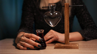 女人女巫准备药水红色的爱药水心形的玻璃Jar