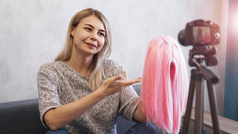 女人博主记录视频显示粉红色的假发设计师时尚顾问