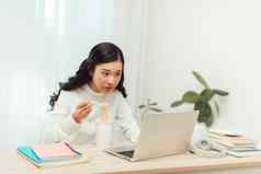 亚洲自由业务女人吃即时面条工作移动PC生活房间首页办公室