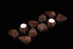 巧克力糖果黑暗背景反射一块一块填充坚果水果