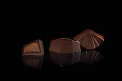 巧克力糖果黑暗背景反射一块一块填充坚果水果