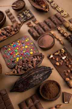 各种各样的巧克力酒吧糖果甜蜜的可可豆荚自然纸背景