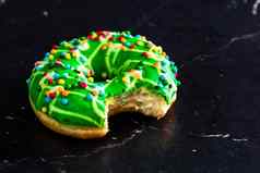 绿色上釉甜甜圈洒孤立的关闭色彩斑斓的咬甜甜圈