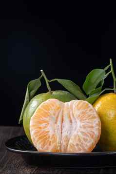 新鲜的绿色橘子普通话橙色黑暗木表格背景
