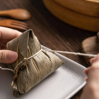 吃粽子龙船节日大米饺子年轻的亚洲女人吃中国人传统的食物木表格首页庆祝活动关闭