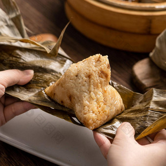 吃<strong>粽子</strong>龙船节日大米饺子年轻的亚洲女人吃中国人传统的食物木表格首页庆祝活动关闭