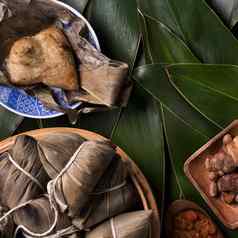 大米饺子粽子传统的中国人食物绿色叶背景龙船节日DuanWu节日前视图平躺设计概念