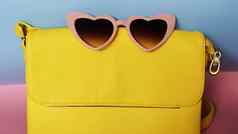 黄色的袋心形的太阳镜粉红色的蓝色的背景