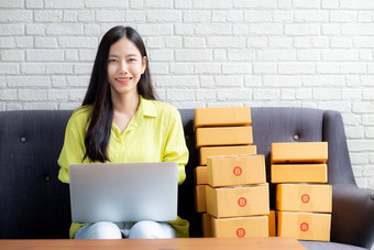 年轻的亚洲女人商人移动PC电脑沙发检查订单客户购买在线购物业务锻造启动企业家卖方服务交付产品