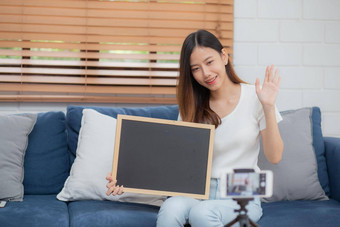 年轻的亚洲女人老师教学语言英语学生电子学习在线首页女孩工作会说话的教训类智能手机保持首页正常的教育概念