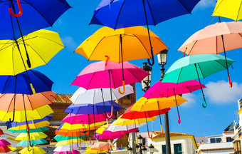 色彩鲜艳的雨伞城市街装饰挂色彩斑斓的雨伞蓝色的天空旅游吸引力