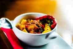 传统的匈牙利菜炖牛肉牛肉土豆西红柿辣椒美味的菜白色碗