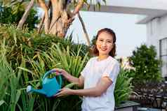 有吸引力的女人浇水花植物花园