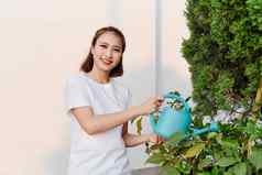 美丽的亚洲女孩浇水植物