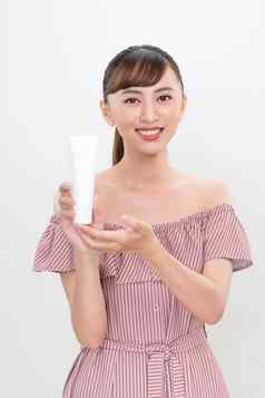 肖像美丽的亚洲女人显示产品白色化妆品管塑料