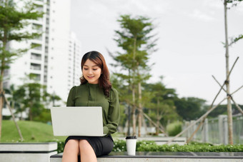 肖像忙销售女人坐着业务公园移动PC<strong>写作文</strong>本移动女商人工作在线