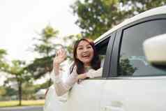 有吸引力的微笑女人挥舞着手车窗口