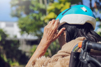 上了年纪的女人后院把安全头保护头盔从风险下降