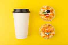 白色纸板咖啡茶杯迷你蛋糕块水果黄色的背景