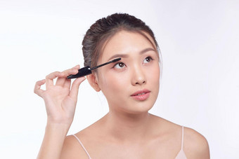 睫毛膏女人把化妆眼睛亚洲女模型脸特写镜头眼睛刷睫毛