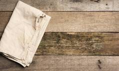 折叠米色亚麻毛巾表格使灰色的木董事会前视图