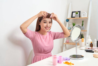 头肩膀肖像美丽的亚洲女人穿头发卷发器镜子宽微笑首页室内背景