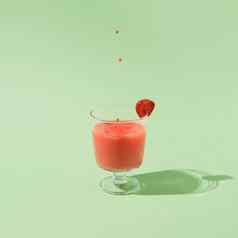 夏天草莓汁下降滴孤立的绿色背景