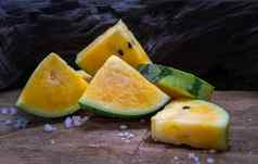 新鲜的多汁的黄色的西瓜减少三角形木背景