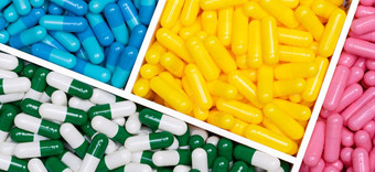 前视图色彩斑斓的胶囊药片塑料盒子粉红色的黄色的蓝色的绿白胶囊药片托盘药店网络横幅制药行业医疗保健背景在线药店概念