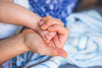 婴儿新生儿概念母亲的手持有新生儿婴儿脚