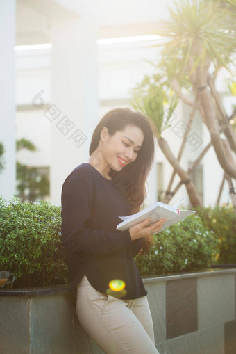 快乐年轻的女人持有书喜欢文学分析休闲时间阳台校园咖啡馆阳光明媚的一天