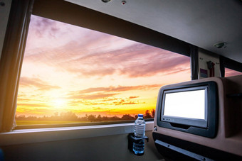 内部公共汽车液晶显示器屏幕空白后座位娱乐瓶水窗口视图美丽的景观自然天空云日落数字旅游路旅行概念