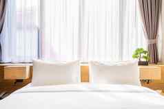 特写镜头白色枕头床上装饰光灯绿色树花盆酒店卧室室内