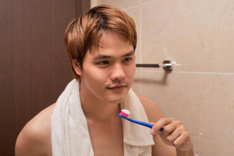 刷牙牙齿早....有吸引力的年轻的男人。刷牙牙齿牙刷镜子
