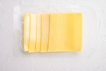 块切达干酪奶酪塑料包白色石头背景前视图平躺