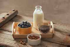 健康的素食主义者早餐瓶装牛奶传讲杏仁新鲜的水果浆果木表格背景复制空间清洁吃重量损失素食者生食物概念