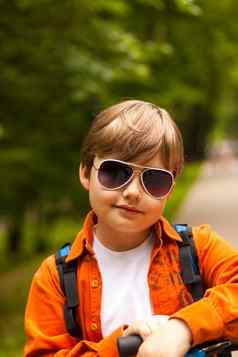 肖像时髦穿着男孩太阳镜概念眼镜年轻的男人。公园阳光明媚的天气