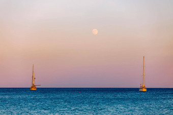 完整的月亮不断上升的水小航行船前景航行船提高月亮日落月亮不断上升的海游艇浮动水表面撒丁岛意大利
