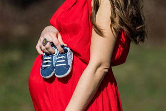 年轻的夫妇等待婴儿期待父母婴儿男孩鞋子概念准父母鞋子运动鞋父母预期婴儿妈妈爸爸未来婴儿鞋子