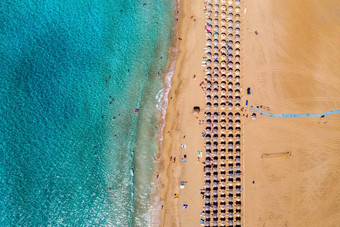 空中视图桑迪海滩色彩斑斓的雨伞游泳人海湾透明的蓝色的水日落夏天空中前视图海滩雨伞沙子海波
