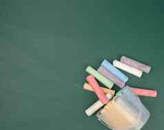 五彩缤纷的蜡笔背景绿色粉笔学校黑板上