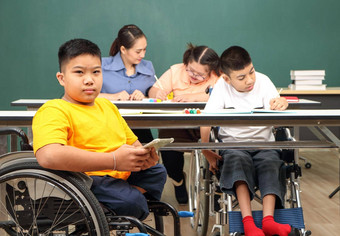 亚洲禁用孩子们自闭症孩子学习读写火车手手指肌肉老师教室桌子上