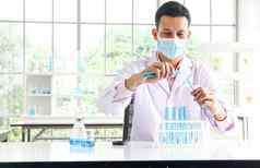 亚洲科学家们化学家实验滴蓝色的液体化学物质实验室