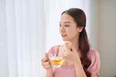 肖像年轻的亚洲女人吃维生素药丸健康护理首页