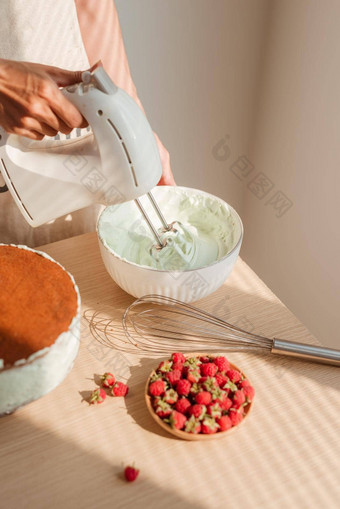 鞭子奶油准备使海绵蛋糕红色的天鹅绒