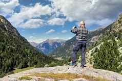 中间岁的旅游男人。图片山移动电话